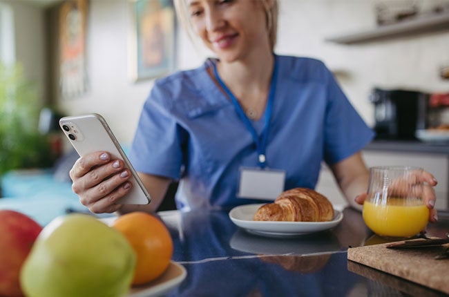 nurse eating and spending time on her phone