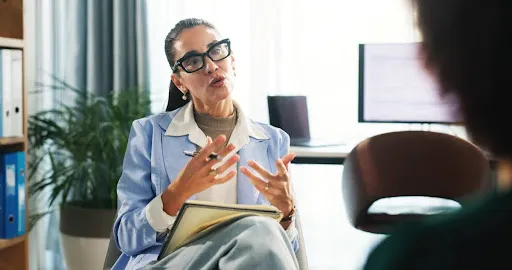 A counselor in an office talking with a client. - Emerging Therapy Modalities - 